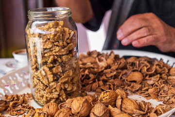 chopped walnut in a man's hand on white background