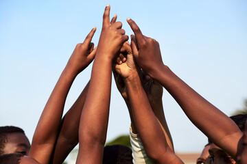 Well rise as a team. Closeup shot of a group of young boys joining their hands together in a huddle.