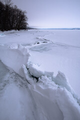 Obraz premium 湖畔の森と御神渡り。冬の北海道の屈斜路湖で。