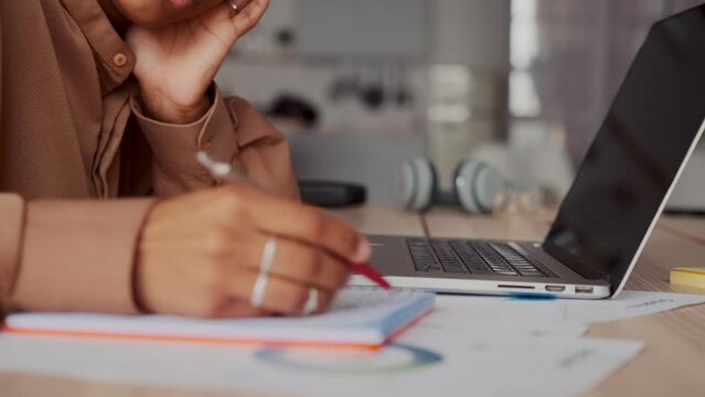 Hands African American woman student typing text on laptop keyboard and taking notes in workbook engaged in getting new education sits at table in own house. Technology, training, advanced training