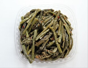 Fern salad in disposable plastic packaging. Pickled fern with spices..