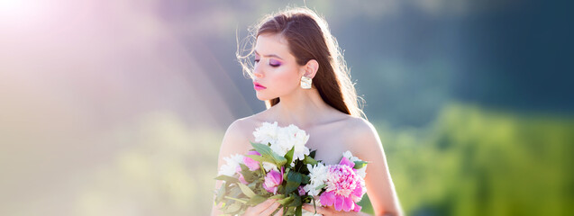 Beauty spring woman face. Happy beautiful young girl relaxing in blossom park. Outdoor fashion photo of beautiful young woman surrounded by flowers. Banner for header website design, copy space.