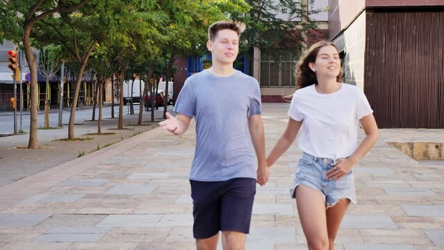 Young man and girl are walking together and talking