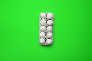 Eier in einem Karton vor einem grünen Hintergrund