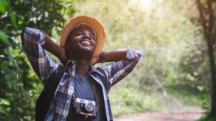 African male tourist travel in wild trip hiking during vacation with holding a film...
