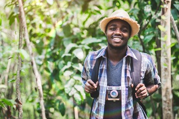 African male tourist travel in wild trip hiking during vacation with holding a film camera,Adventure travel concept