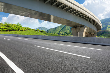 Empty asphalt road and bridge with mountains background