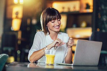 Beautiful attractive woman at the cafe with a laptop having a coffee break