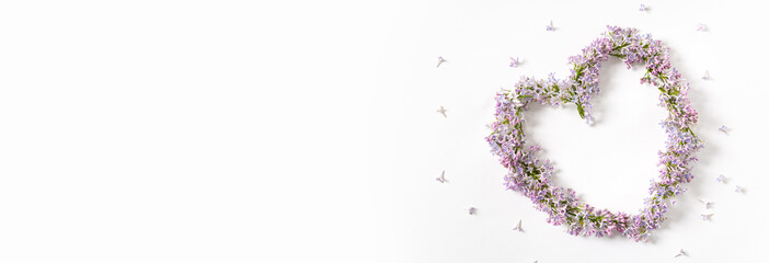 Creative spring banner. Beautiful lilac flowers in heart shape and copy space for text on a white background. Springtime web line, floral design. Spring sale, promotion banner. Flat lay.