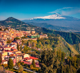 Sunny summer view from flying drone of Taormina town and Etna volcano on background. Picturesque...