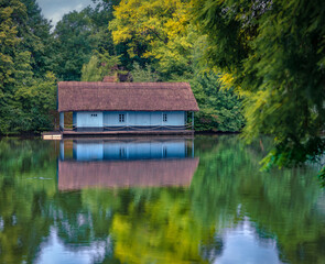 Small fishing chalet with straw roof among green fresh lievs in King Mihai I of Romania Park (Herastrau Park), Bucharest, Romania, Europe. Beauty of countryside concept background.