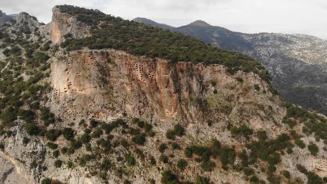 Remains of ancient Lycian rock hewn tombs in stone cliff in city of Pinara in Turkey