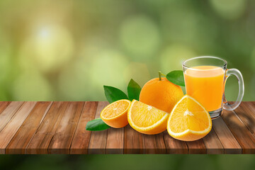 A glass of orange juice and oranges fruit on a wooden table in green nature background.