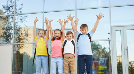 Group of children celebrating success near school building