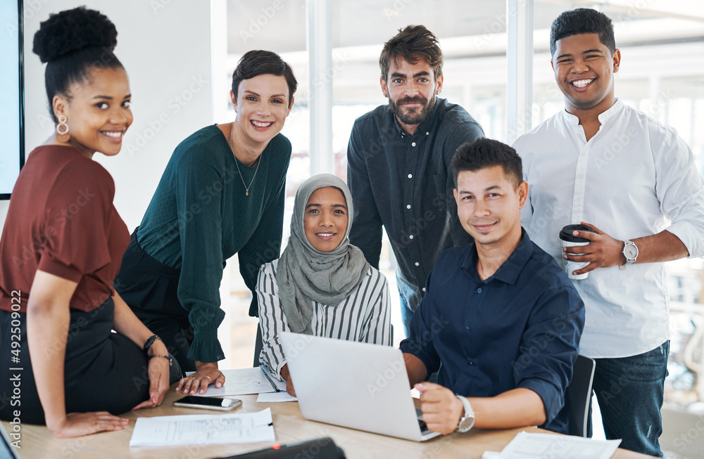 Poster pulling off a project like only we can. shot of a group of businesspeople using a laptop during a me