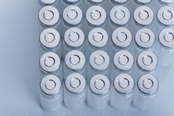 Glass medical ampoule vial for injection. Medicine is dry white drug penicillin powder or liquid with of aqueous solution in ampulla. Close up. Bottles ampule with aluminum cap on backgrounds gray.