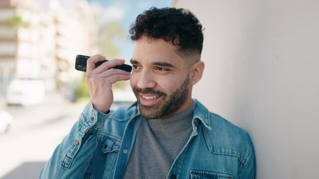 Young arab man smiling confident listening audio message by the smartphone at street