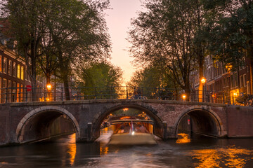 Pink Sunset on the Amsterdam Canal and a Boat Under the Bridge