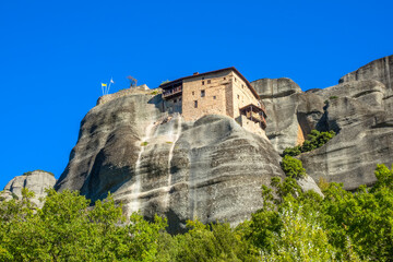 Greek Monastery on a Rock Against the Blue Sky