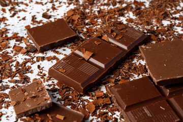 Grated chocolate and pieces of tasty chocolate on table