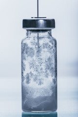 Medicine, Injection, vaccine and disposable syringe, drug concept. Sterile vial medical syringe needle. Macro close up. Glass medical ampoule vial for injection. Bottles ampule with aluminum cap.