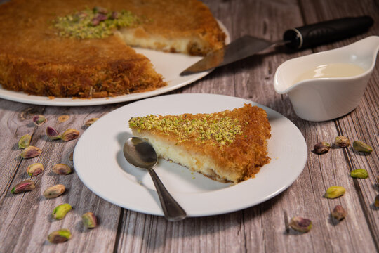 Delicious Traditional Dessert Knafeh with cheese and pistachios and orange flower syrup, High quality photo
