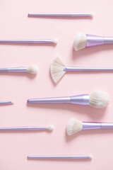 Different makeup brushes on pastel pink background. Magazine, social media. Beauty and Fashion. Visagist tools. Top view, close up. Creative flat lay. Cosmetics products