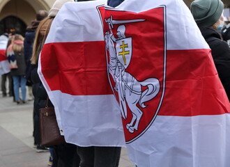 People covered with flag of Belarus used by political opposition during street demonstration
