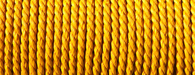 Yellow rope texture. Horizontal panoramic rolled rope background. Strong line looped in coil.