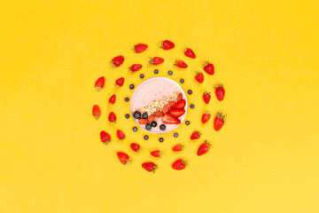 strawberries on yellow ground around bowl