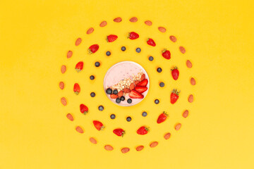 strawberries on yellow ground around bowl