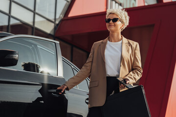 Elegant Female Entrepreneur with Briefcase in Hand Opening Door of the Luxury Car