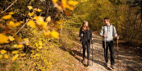 Young couple hikino on a warm autumn afternoon in nature