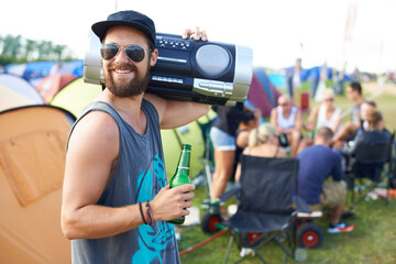 Rocking out with my boombox. Shot of a guy carrying a boom-box on his shoulder and drinking a beer at an outdoor music festival.