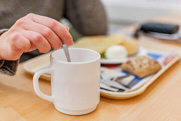 Close up of female hand with cup at breakfast.