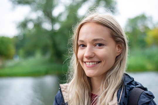 Happy young woman with blond hair at park