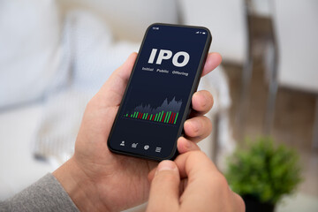 male hands hold phone with IPO stocks purchase app