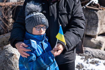 Families against war. Upset Ukrainian boy with his grandmom, with bue yellow flag, protesting war...
