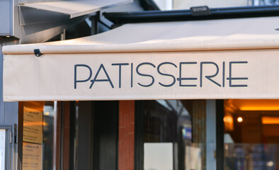 Patisserie pastry shop sign in front of the store on the streets of Paris, France.