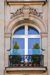 Fototapeta na wymiar Beautiful facade of a building from Paris, France, with a lot of plants and elegant architecture details and decorations.