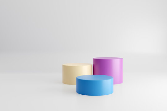 Pastel colored pedestals or platforms in round cylinder shape with white studio background for product display.