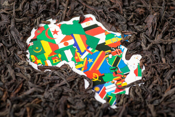 Map of Africa continent surrounded by dried black tea leaves. Concept of tea business in African...