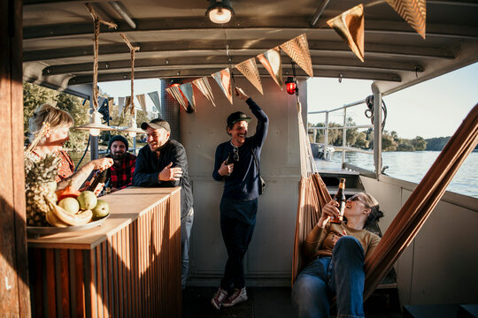 Smiling friends spending leisure time together on boat