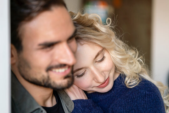 Smiling young woman with blond hair embracing boyfriend