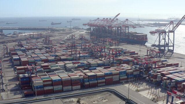 Cargo containers in busy port, aerial. Shipping containers in the port city. Top view of shipping containers in the port city. Intermodal Shipping Containers In An Industrial Port.