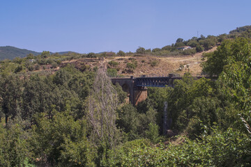 The iron bridge in Hervás, Cáceres, Extremadura, Spain. Bridge surrounded by vegetation located...