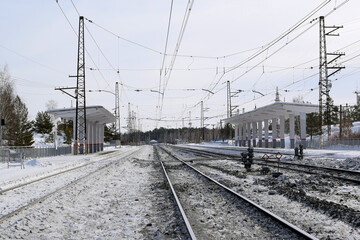 Fototapeta na wymiar Empty railway track and empty passenger platform, winter landscape.