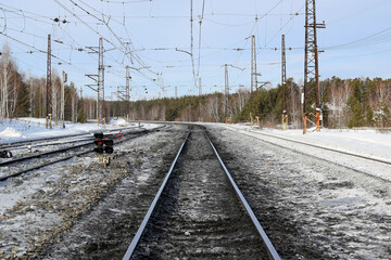 Railway tracks go into the distance beyond the horizon, winter landscape.