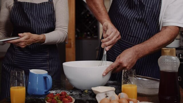 Mature romantic couple baking in kitchen 