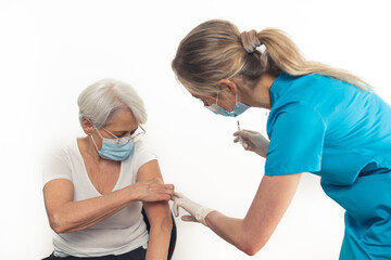 Obraz premium Pensioner woman in her 70s gets a vaccine booster. Copy space. White background. High quality photo